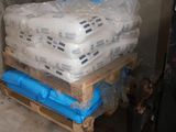 a dog that is standing next to a pallet full of ice