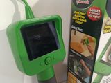 a green handheld camera sitting next to a box of food