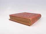 an old book that is sitting on a white surface