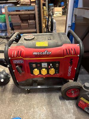 a red and black generator on the floor in a garage