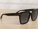 a pair of black sunglasses sitting on top of a wooden table