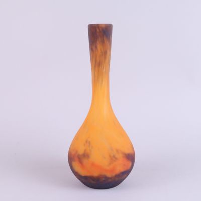 un petit vase posé sur une surface blanche