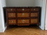 a dresser in the corner of a room with a mirror above it