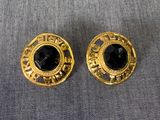 une paire de boucles d'oreilles dorées ornées de pierres noires