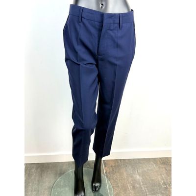 Le mannequin porte un costume bleu et des chaussures noires.