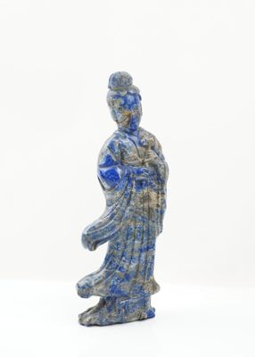 une statue bleue et blanche représentant une femme tenant une fleur