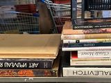de nombreux livres empilés sur une étagère métallique dans un magasin