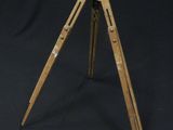 an old wooden tripod with a black background