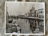 a black and white photo of a harbor with boats