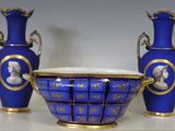 trois vases bleus posés sur une table aux bordures dorées