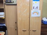 a wooden cabinet in the middle of a messy room
