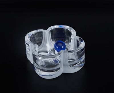 a clear glass cup with a blue lid on a black surface