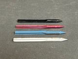four different colored pencils are lined up on a table