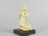 une photo d'une sculpture représentant une femme assise sur un socle en marbre