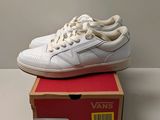 une boîte sur laquelle est posée une paire de chaussures blanches