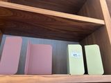 une étagère en bois sur laquelle sont posés une bibliothèque et une horloge