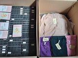 a lot of shirts in a box with labels on them
