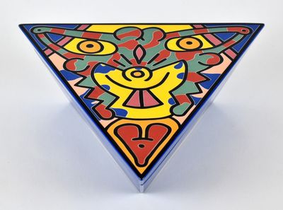objet de forme triangulaire aux couleurs vives, avec un visage au centre