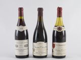 three bottles of wine are lined up on a white surface