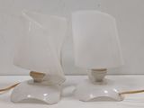 pair of white glass lamps with a wooden base on a white surface