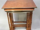 a pair of wooden tables with brass trims on top of them