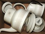 une boîte remplie de tasses à café blanches et de soucoupes