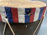a drum with a red, white and blue stripe on it