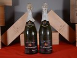 two bottles of champagne sitting next to each other on a table