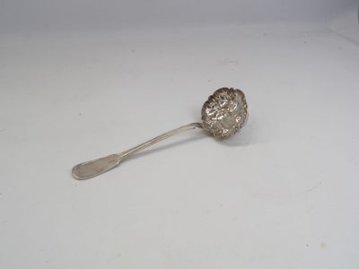 une cuillère en argent avec un manche de cuillère sur une surface blanche