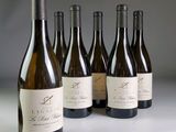 six bouteilles de vin sont alignées sur une table