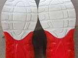 pair of red and white tennis shoes with white soles on a gray surface