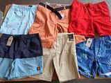 Plusieurs paires de shorts pour hommes sont posées sur une boîte en carton