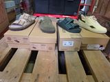 plusieurs paires de chaussures posées sur des cartons, sur une palette
