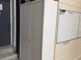 un réfrigérateur blanc posé dans un garage, contre un mur
