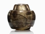 un vase brun posé sur une surface blanche