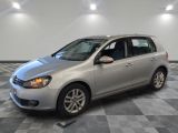 the silver volkswagen golf is parked in a large room