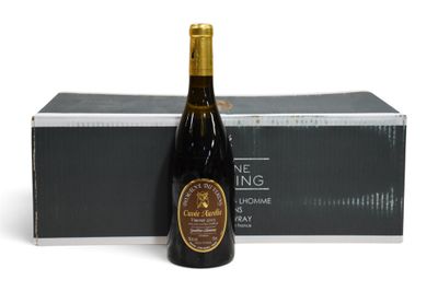 une bouteille de vin posée à côté d'un carton de vin sur une surface blanche