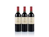 three bottles of red wine sitting next to each other on a white surface