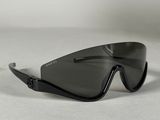 une image représentant une paire de lunettes de soleil noires posée sur une surface blanche
