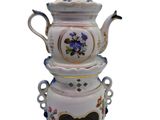 a white tea pot with a blue and yellow flower design on it