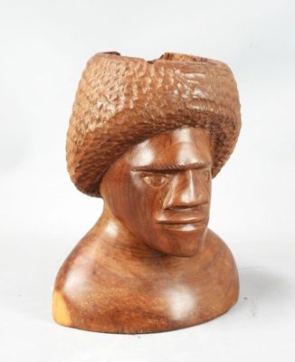 wooden sculpture of a man with a hat on top of his head