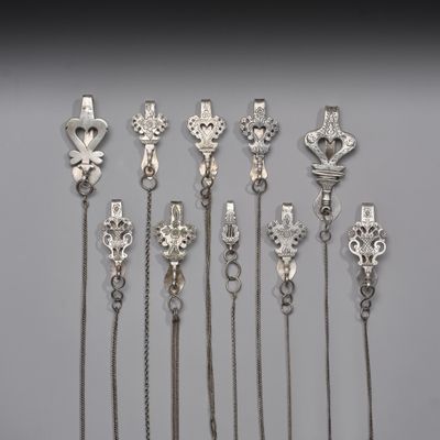 un lot de sept cuillères en argent avec des chaînes et des breloques