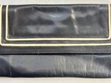 porte-monnaie en cuir noir avec des finitions dorées sur fond blanc
