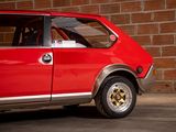 a red car that is parked in front of a brick wall