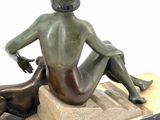 statue of a woman sitting on a stone block with a dog