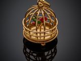 a close up of a gold bird cage with a rose in it