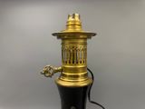 une image représentant une lampe noire et dorée allumée
