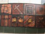 painting on the wall of a building with a cross and other religious symbols