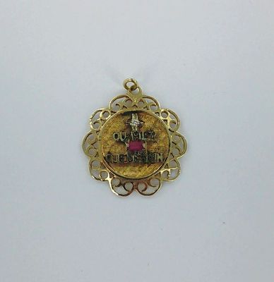 une image représentant un pendentif plaqué or orné d'un château