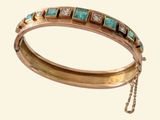 bracelet composé de pierres turquoise et blanches montées sur une chaîne, sur fond blanc
